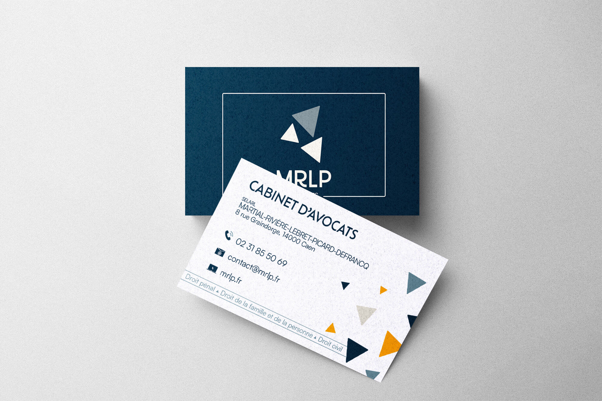 Mockup de cartes de visite du cabinet “MRLP Avocats” conçues par Gaële Gerbaux du studio nueva vista : recto bleu marine avec logo géométrique en triangles, et verso blanc avec coordonnées professionnelles, pictogrammes et motifs triangulaires bleu, gris et jaune, dans un design corporate élégant.