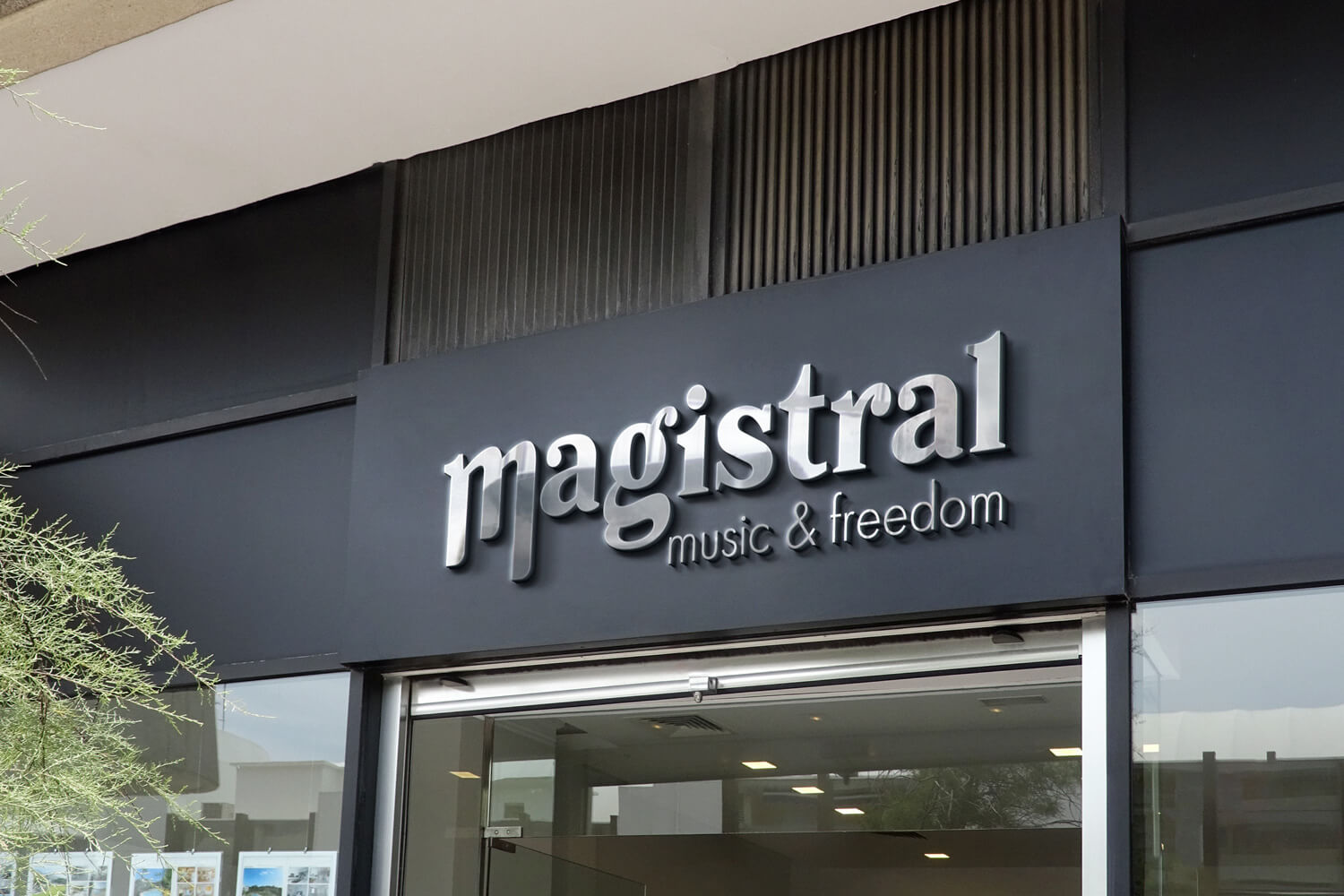 Enseigne extérieure du magasin d’instruments de musique “magistral”, présentant le lettrage 3D “magistral – music & freedom” conçu par Gaële Gerbaux du studio nueva vista, installé sur une façade noire moderne.