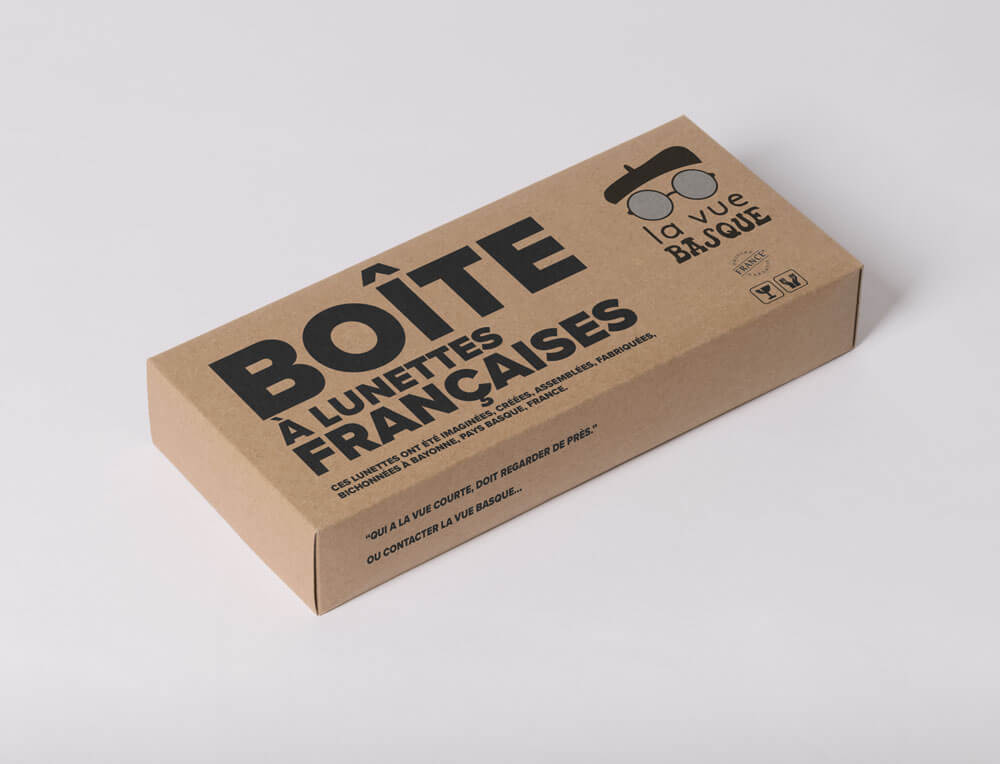 Packaging en carton pour boîte à lunettes françaises présentant l’identité visuelle “La Vue Basque” conçue par Gaële Gerbaux du studio nueva vista : logo avec lunettes rondes et béret basque, typographie noire audacieuse “Boîte à lunettes françaises” et mentions de fabrication locale.
